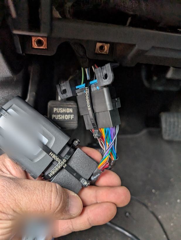 Telematics module and wiring harness connectors held under a dashboard